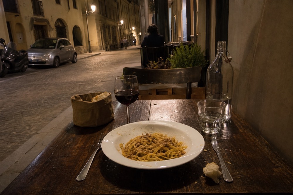 A Piemontese table with tajarin pasta and a glass of red wine.