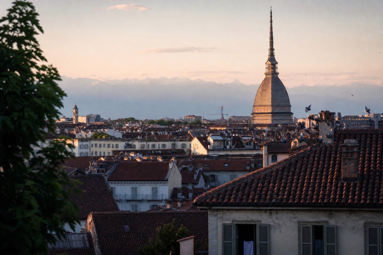 Turin's arcaded streets and the Mole Antonelliana seen across the city rooftops.
