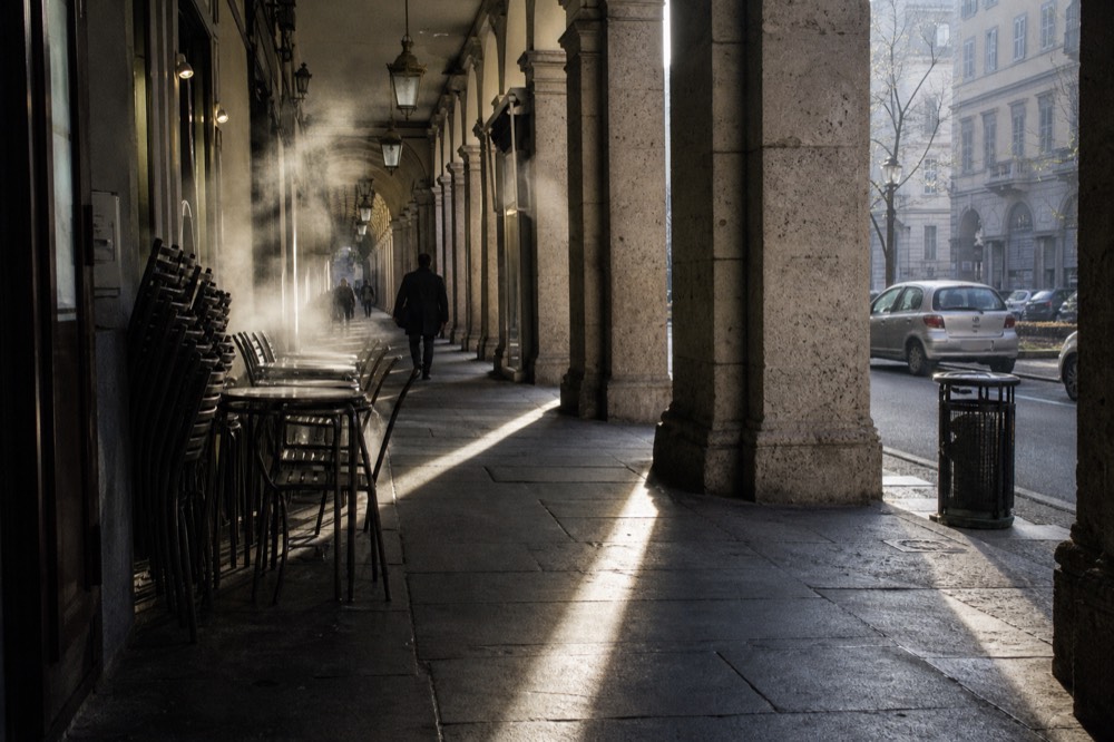 Arcaded neoclassical street in central Turin with morning light on the columns.