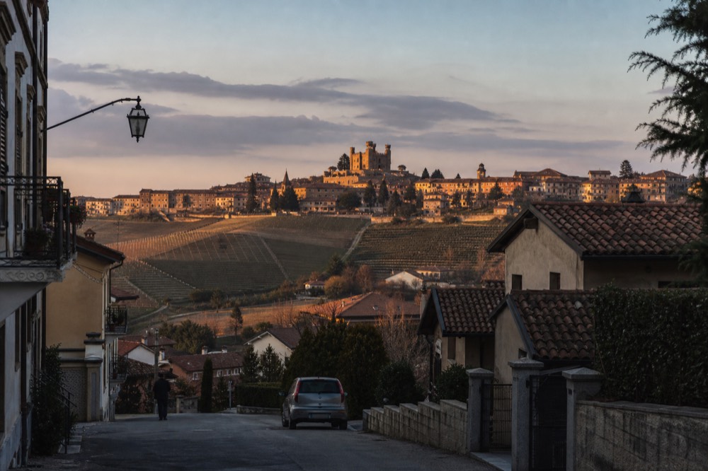 Evening light on Barolo village rooftops with the castle and hills.